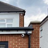 Two security cameras on brick wall