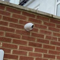 Brick wall with CCTV camera pointing downwards