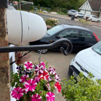 Camera view of driveway overlooking van and car
