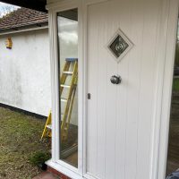 White front door with CCTV camera in the background