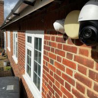 Closeup of 2 security cameras on side of Essex home