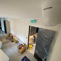 White Hikvision camera overlooking hallway