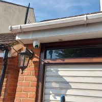 CCTV camera on white fascia above garage